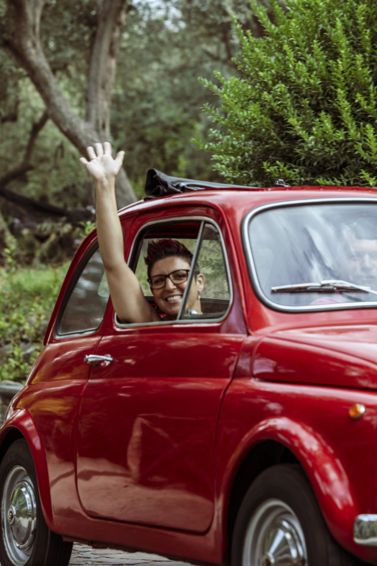 A lady driving a classic red car in Amalfi