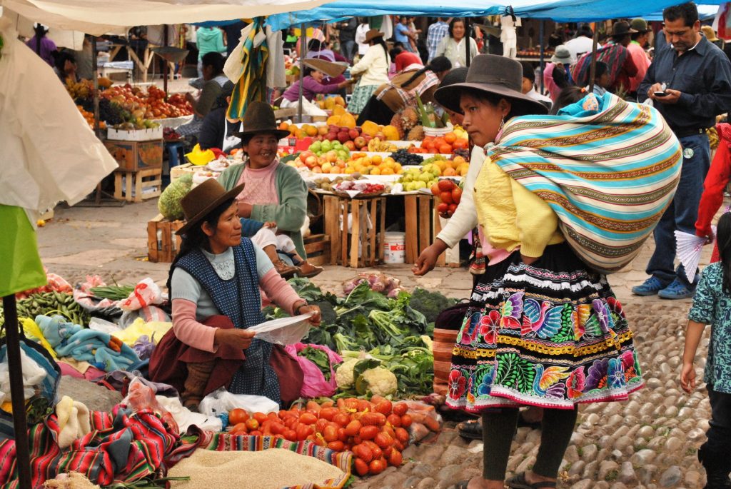 Women buying and selling fruit at Peruvian market in a village near Cuzco.
