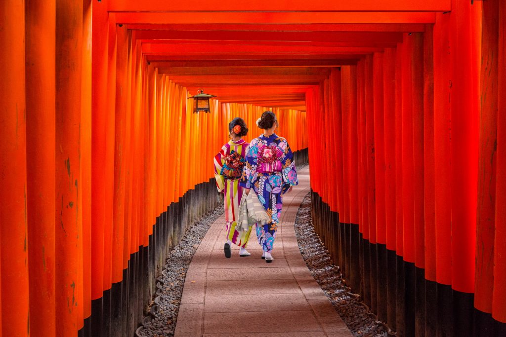 Women in traditional Japanese kimonos walking in Fushimi Inari Shrine in Kyōto, Japan.
