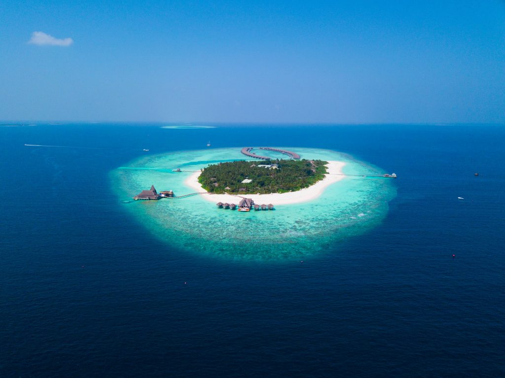 Maldivian island surrounded by turquoise water in Indian Ocean