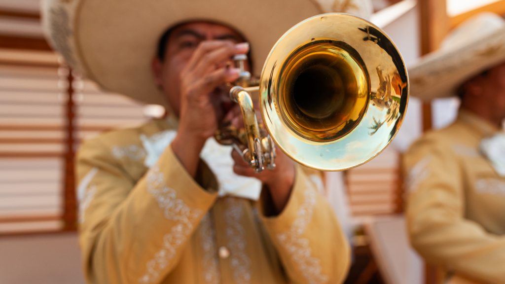 A man plays trumpet in a mariachi band typical of Mexico