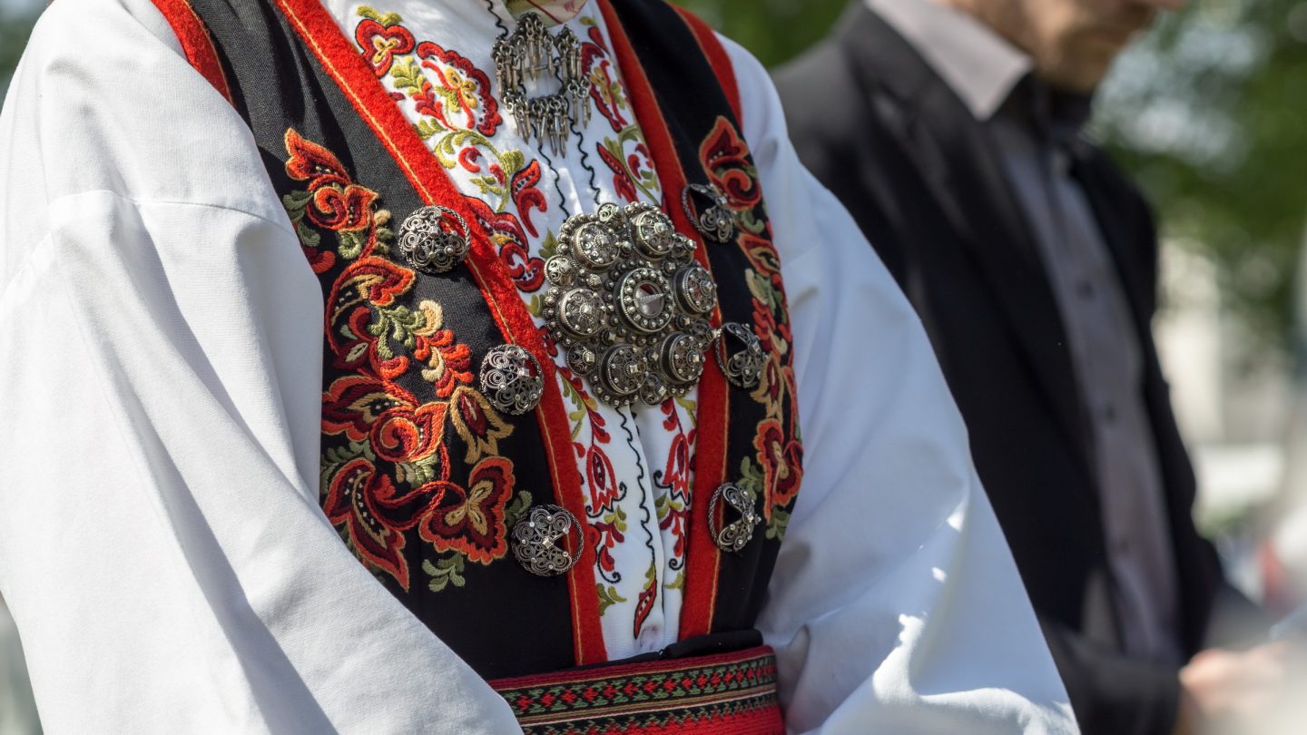 A woman wearing a traditional Norwegian costume at a folk festival.