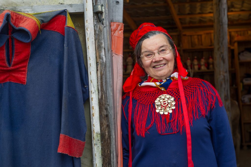 A smiling sami woman dressed in her traditional clothes