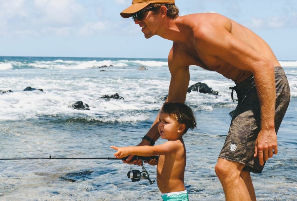 Father and son fishing on a beach