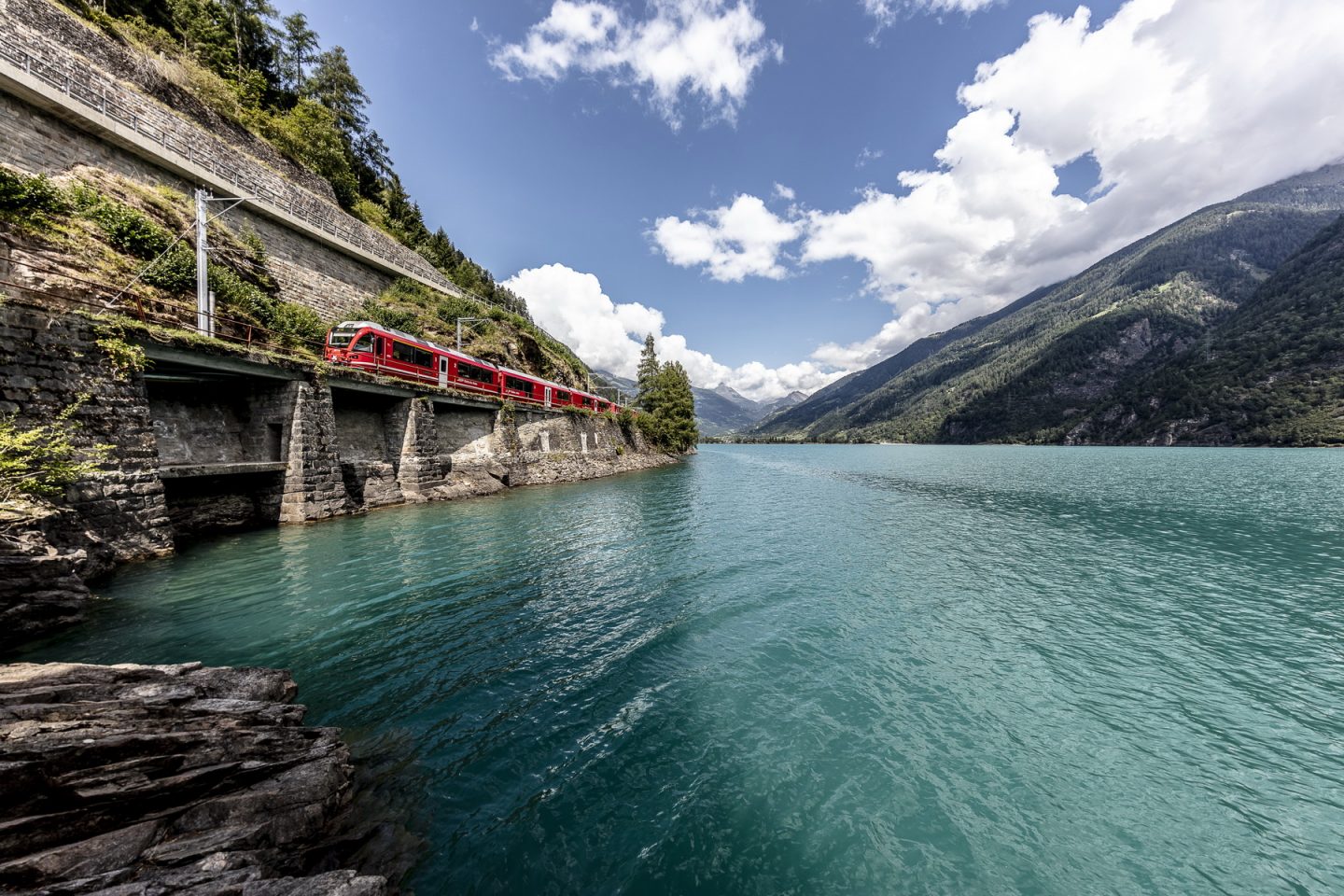 The Bernina Express train passing the picturesque Lago di Poschiavo in southern Switzerland