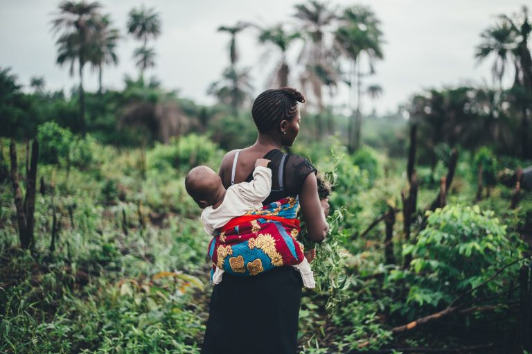 african woman gardening with her baby
