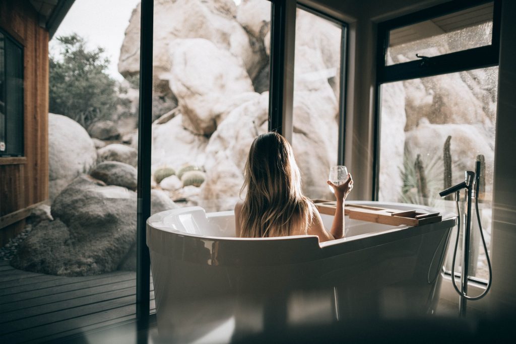 woman enjoying bath and drink while enjoying amazing view