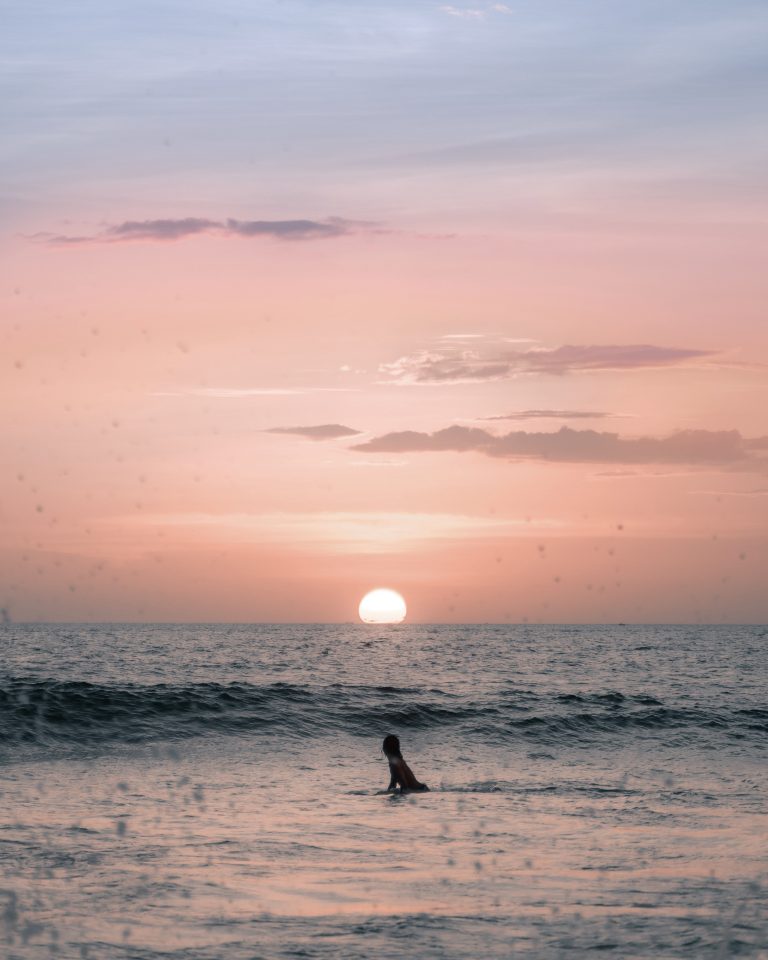 surfer enjoying beautiful sunset in ocean