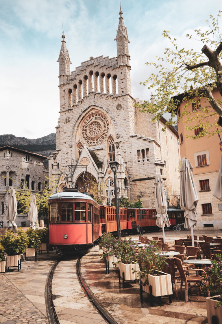 tram in the downtown of mallorca in front of medieval gothic cathedral