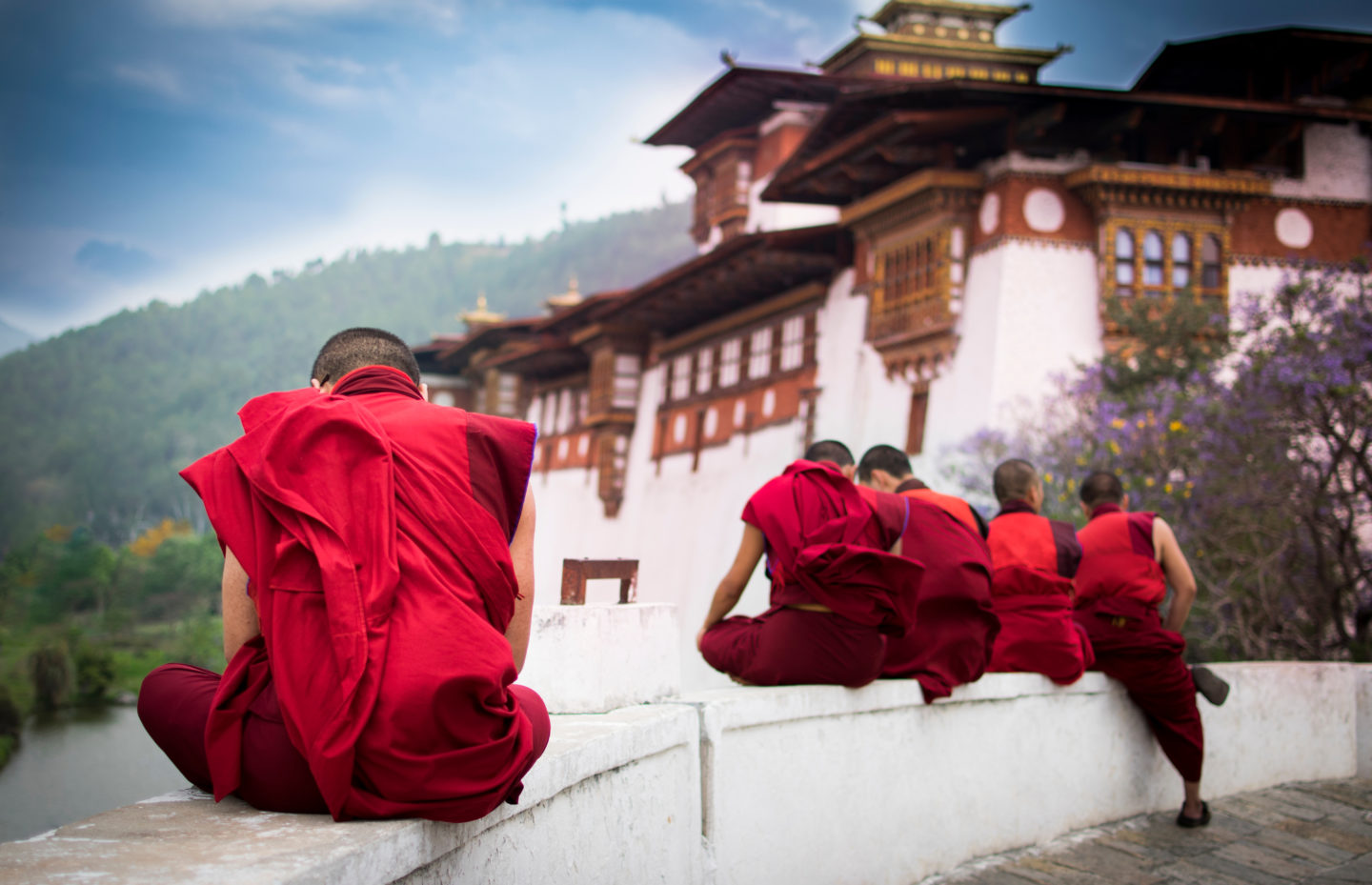 Buddhist Monk sitting on Monastery wall in Bhutan