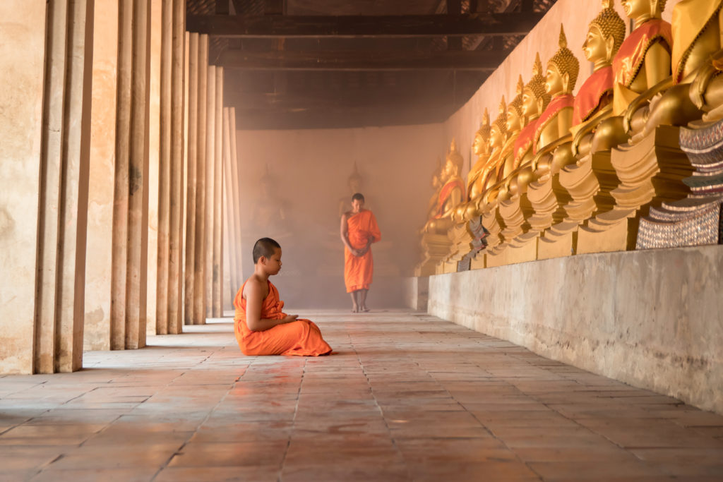 Young novice monk sitting for meditation in temple of Bhutan