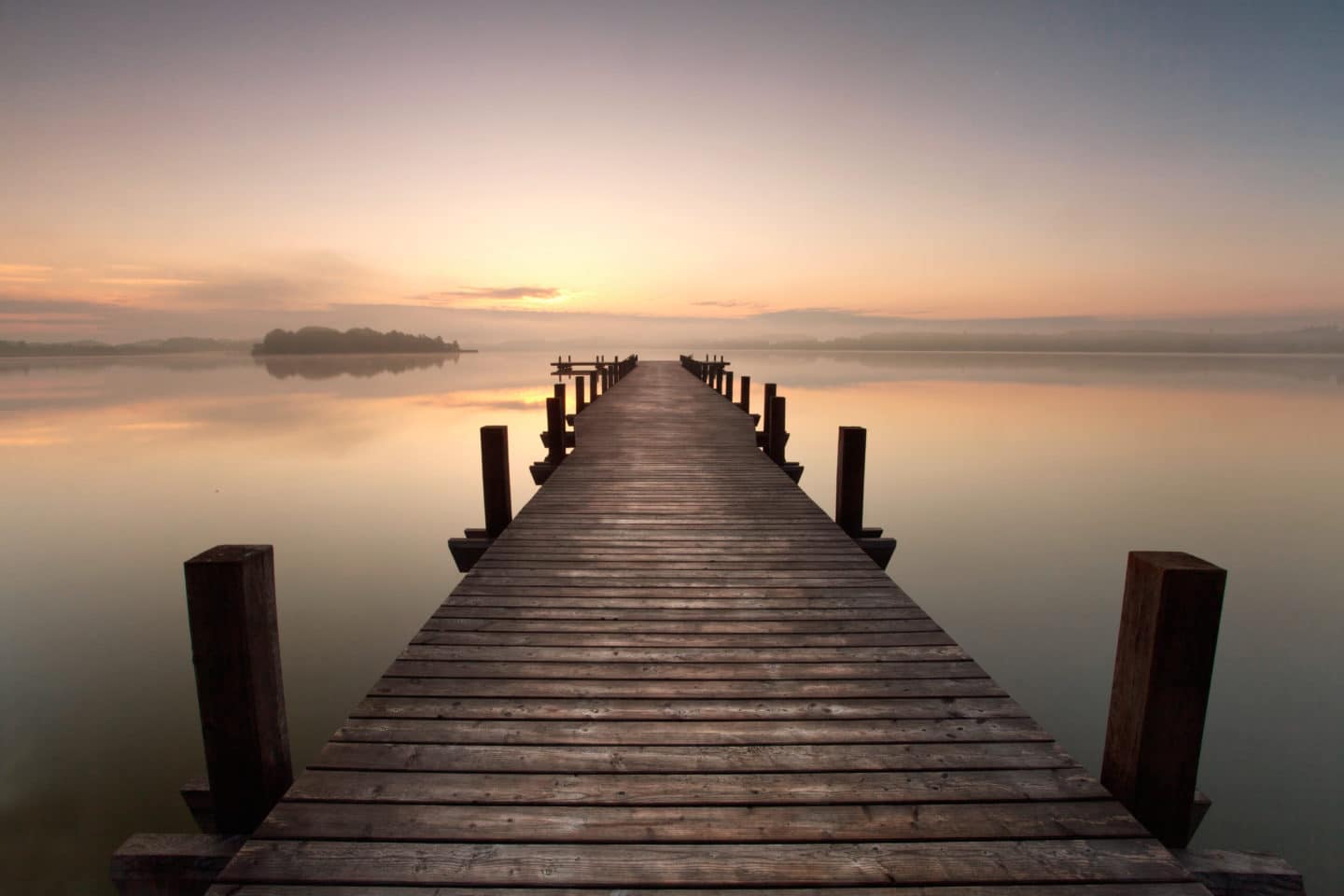 a long pier leading out onto the lake