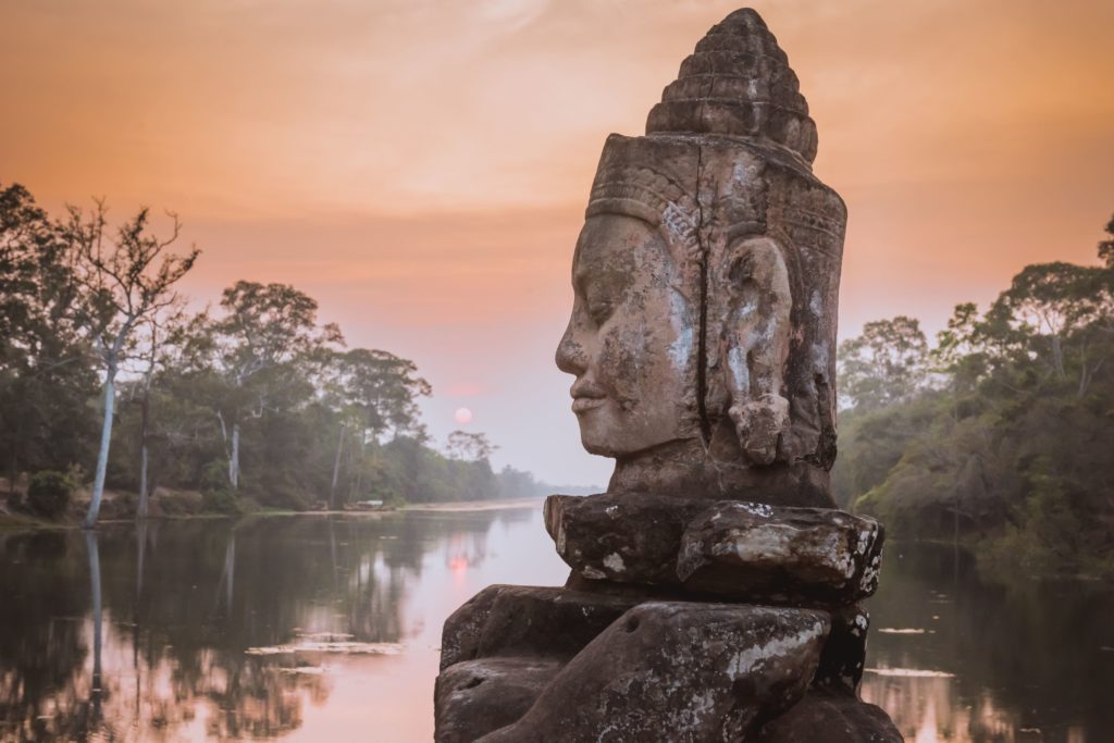 Beautiful sunset over the stone Asura on the causeway near the south gate of Angkor Thom in Siem Reap, Cambodia.