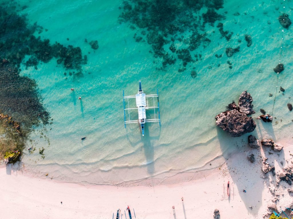 An aerial view captures a fishing boat off the coast of Boracay, a stunning island in the Philippines.