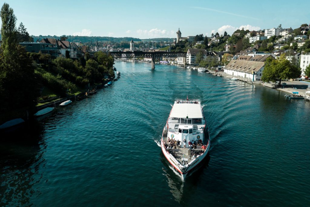Summer view of a ship on the Rhine River, with the historic old town and Munot fortress in Schaffhausen, Switzerland.