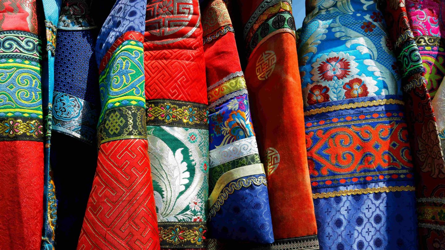 Display of fabric pieces with various colors and designs, representing cultural style and art form.