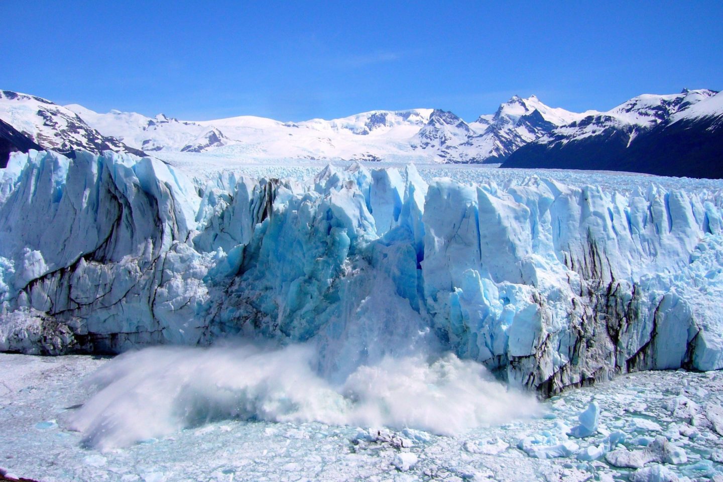 A glacier with jagged ice formations and misty cloud at its base.