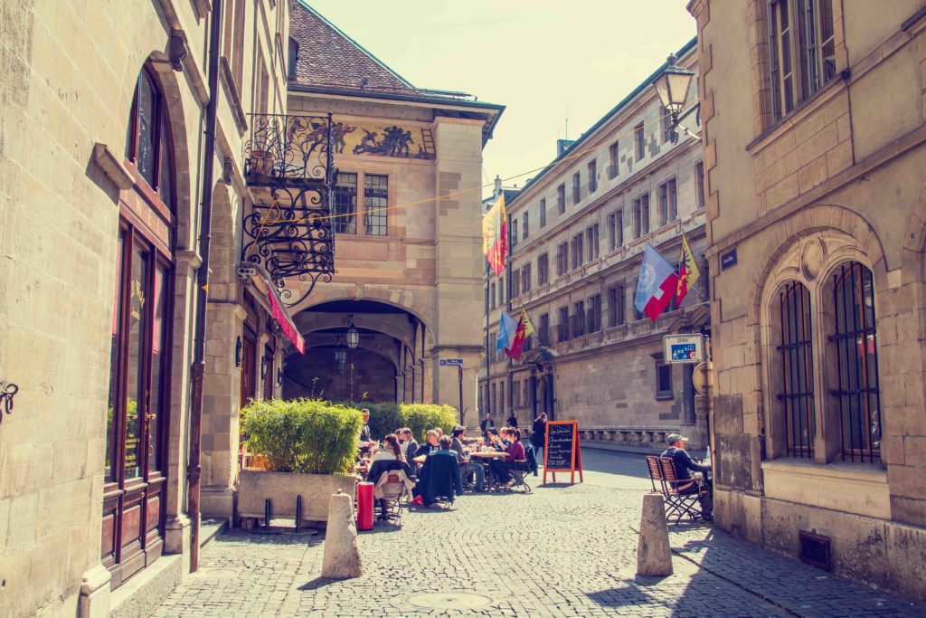 Charming scene in Geneva, Switzerland, with an old building and a restaurant nestled in Geneva Old Town, capturing the historic ambiance of the city.