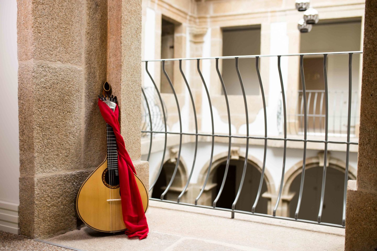 A close-up shows the delicate beauty of a fado guitar within the walls of an old building.