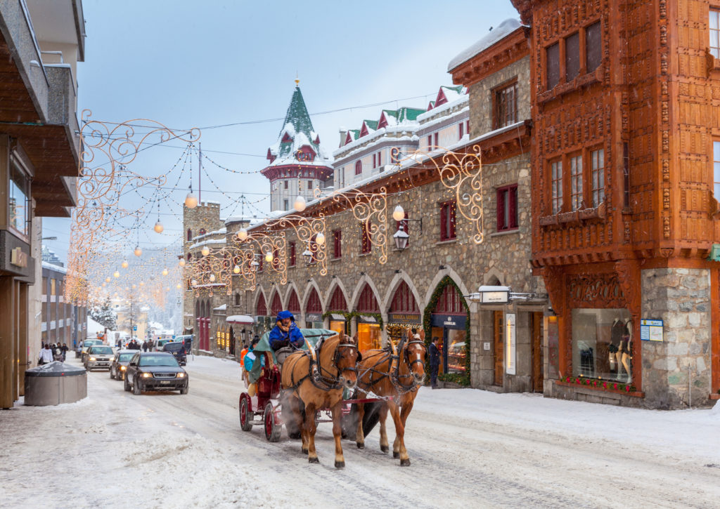 A horse-drawn carriage on a street in the historic center of St. Moritz adds a touch of timeless elegance to the charming Swiss Alpine landscape.