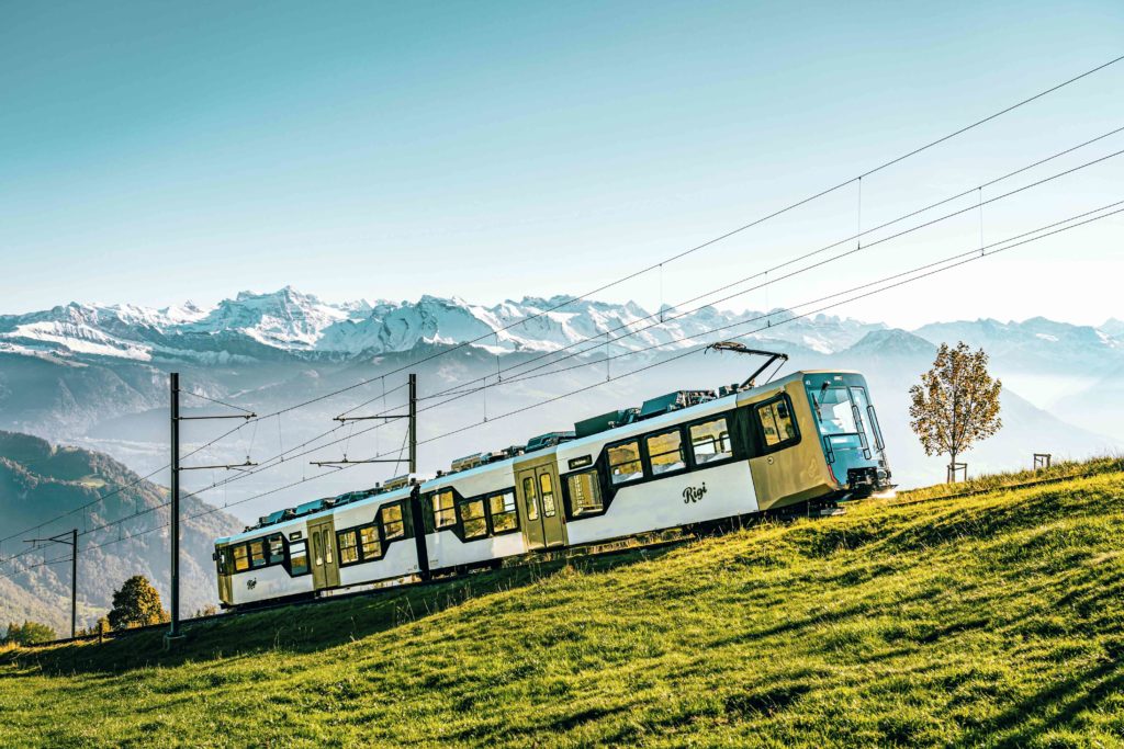 Rigi Kulm Railway ascending against a backdrop of majestic mountains, showcasing the scenic journey through breathtaking landscapes.