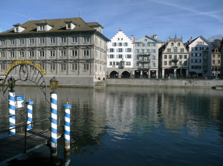 A peaceful evening scene capturing the reflection of city buildings on bank of Limmat Zurich