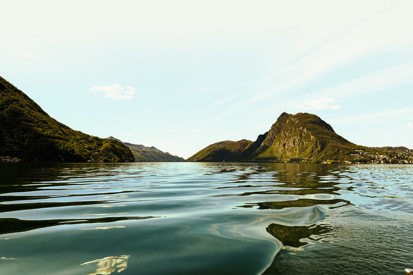 The mirror-like surface of a lake capturing the sky’s hues, surrounded by mountains