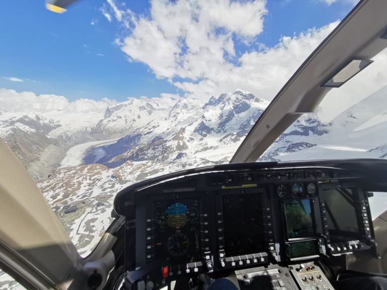 A breathtaking aerial shot of majestic mountains seen from the inside of a helicopter.