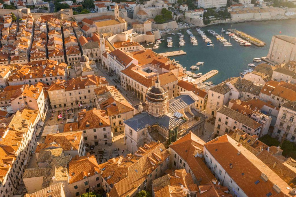 Aerial view reveals Dubrovnik Cathedral overlooking the historic harbor in Croatia.