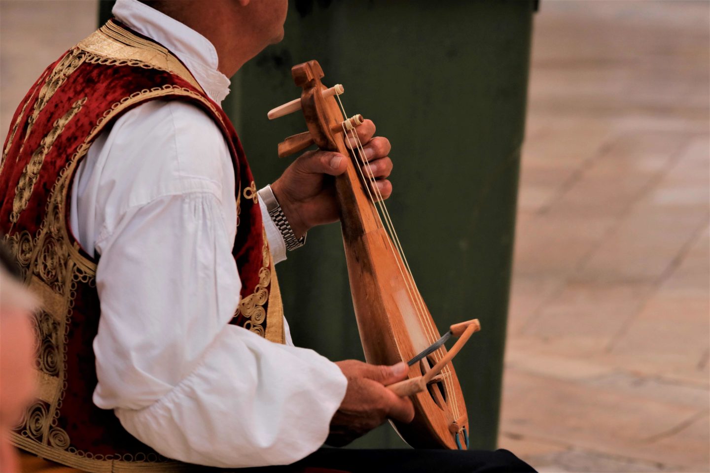 Croatian street musician in traditional costume plays a typical Dalmatian lute called Lijerica in Dubrovnik, Croatia.