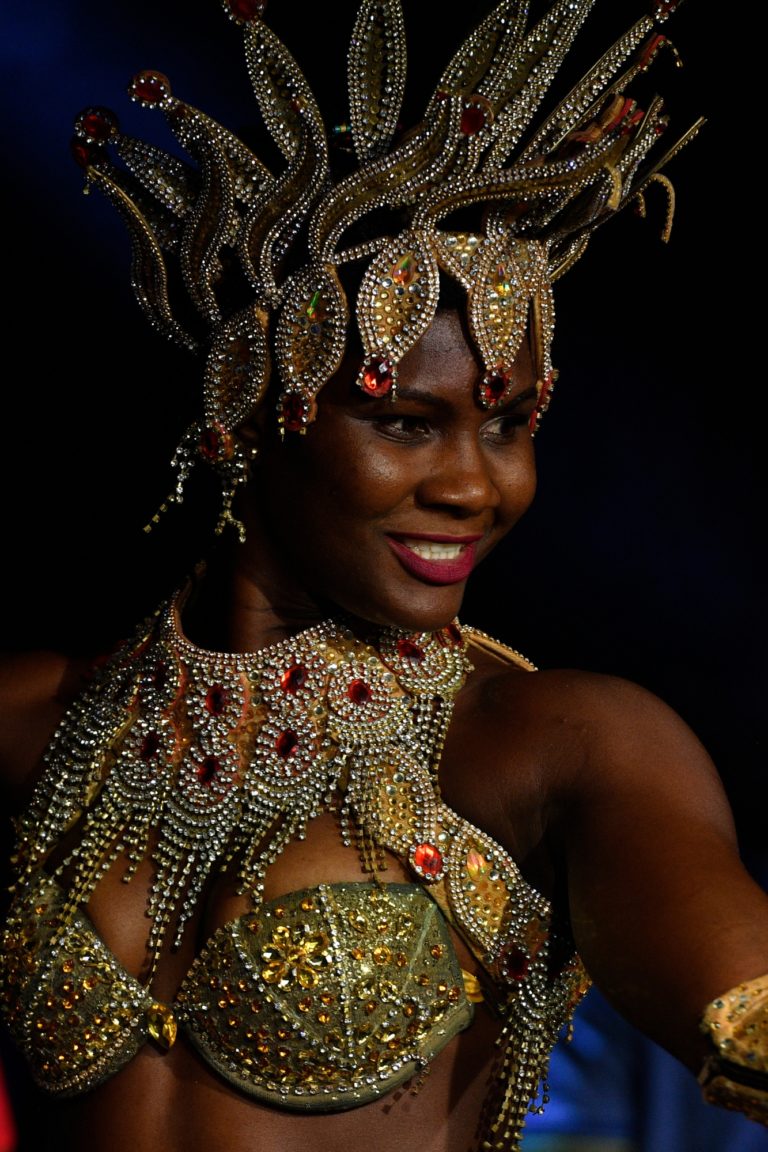 A dancer with lots of jewelry smiles at the guests of an event in Cape Verde.