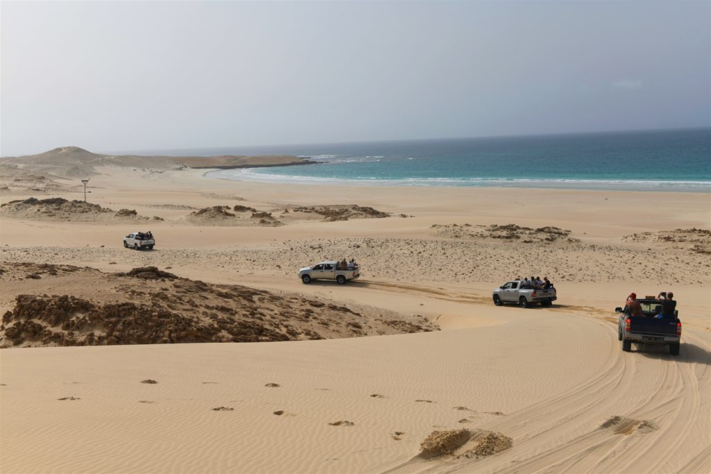 A convoy of off-road vehicles drives on the dunes of Boa Vista in Cape Verde during an event.