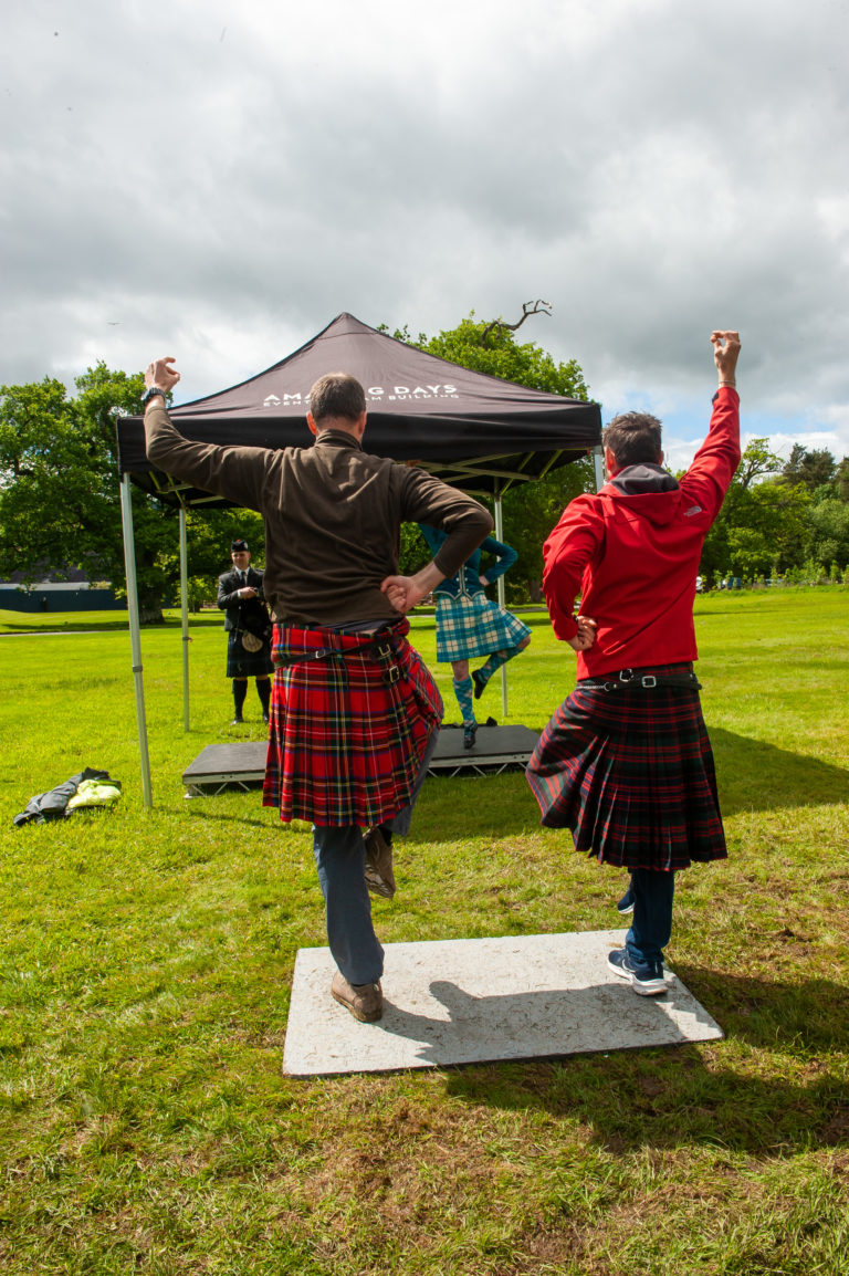 Two men try their hand at Highland dancing during an event in Scotland.