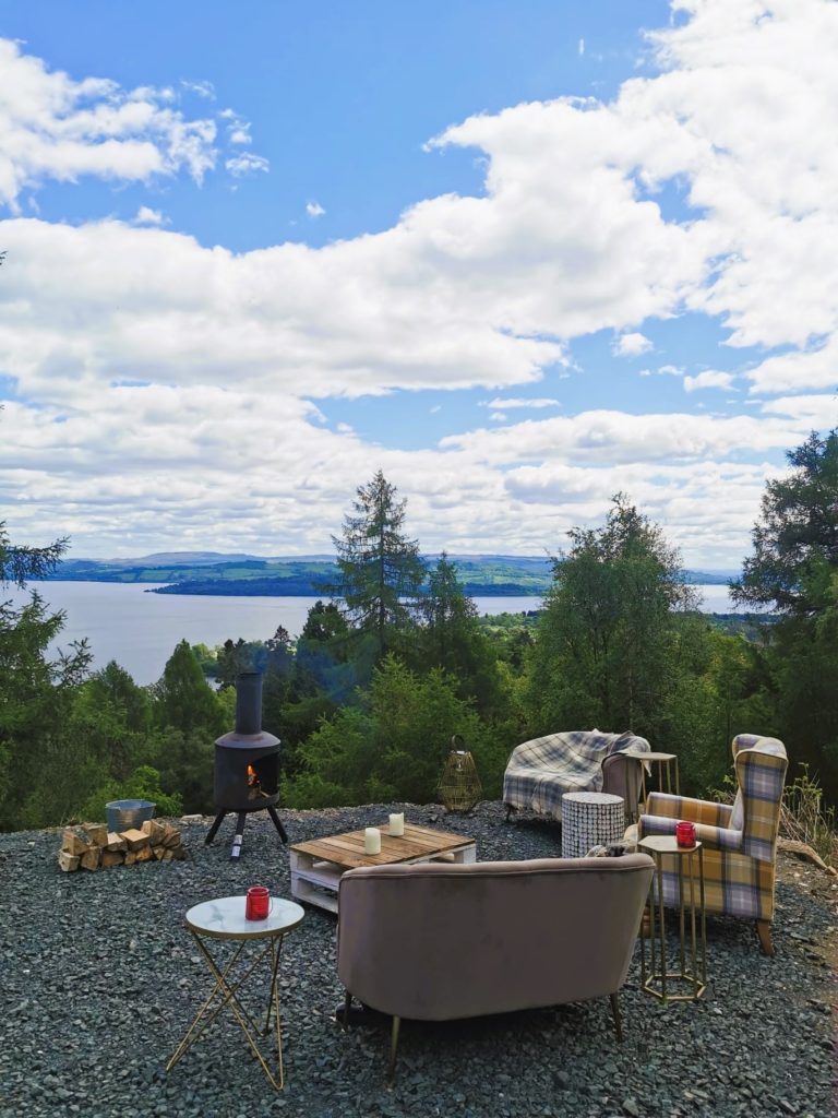 A cozy corner with sofas and an oven overlooking of Loch Lomond.