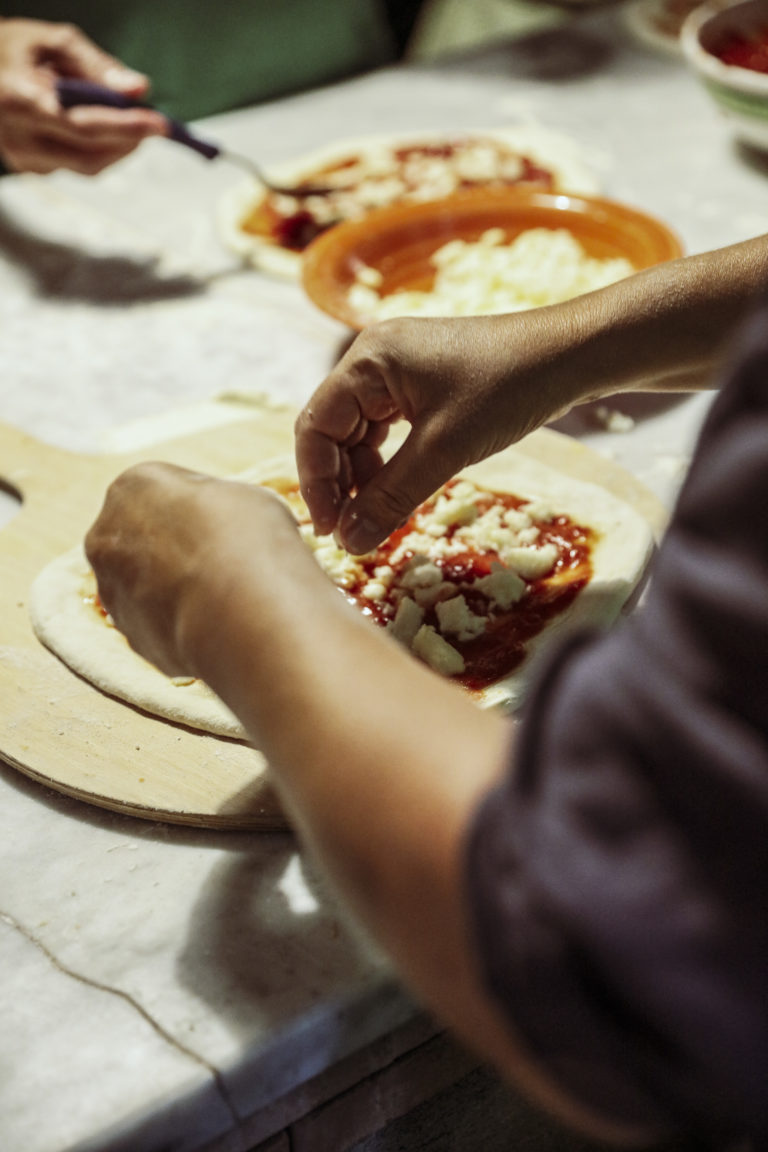 A man prepares a pizza during a cooking class.