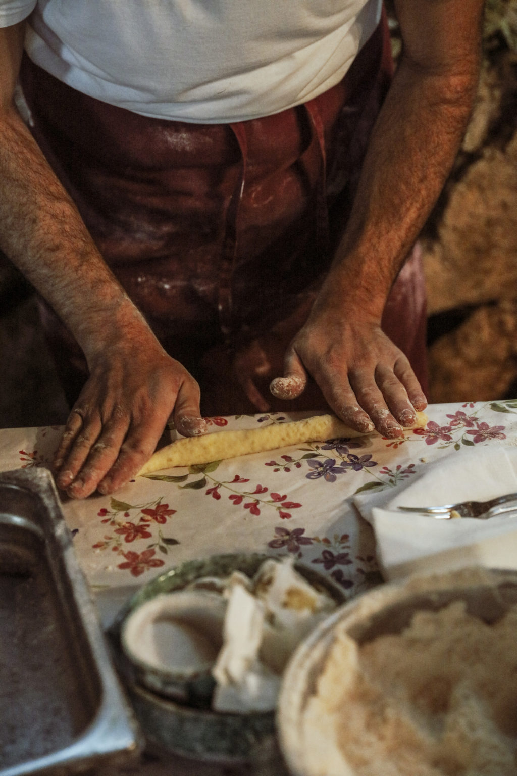 A man rolls the dough in order to make gnocchi during the cooking class.