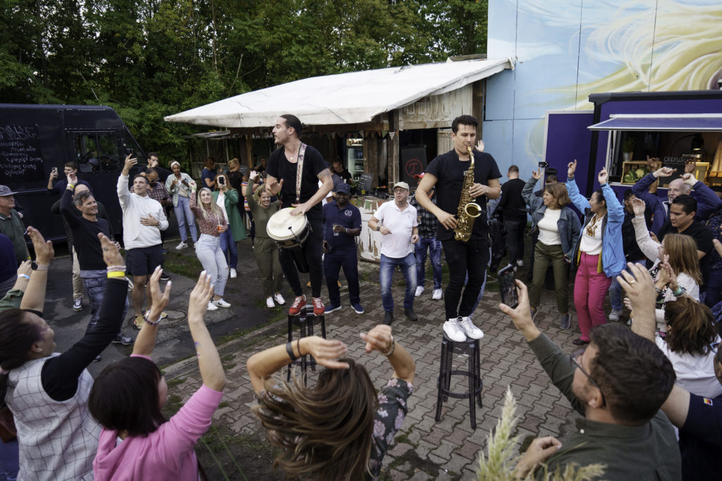 Musicians with saxophone and drums entertain guests during an event in Berlin.