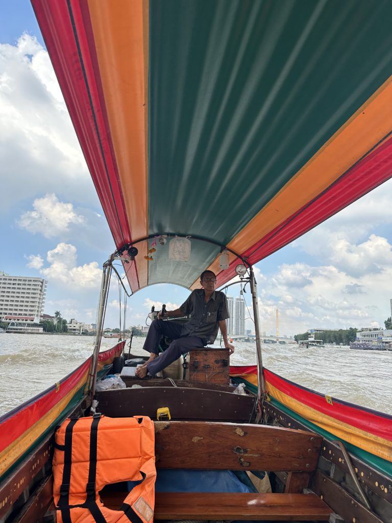 The driver of the longtail boat looks ahead in Bangkok, Thailand.