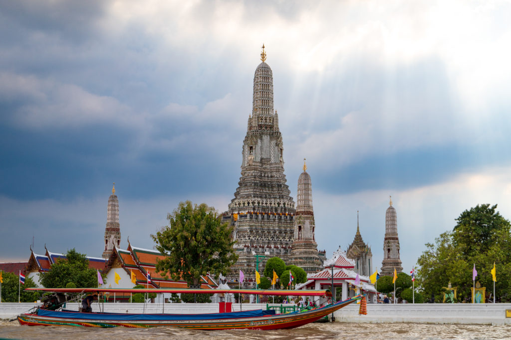 A longtail drives past the Wat Arun temple in Bangkok, Thailand.