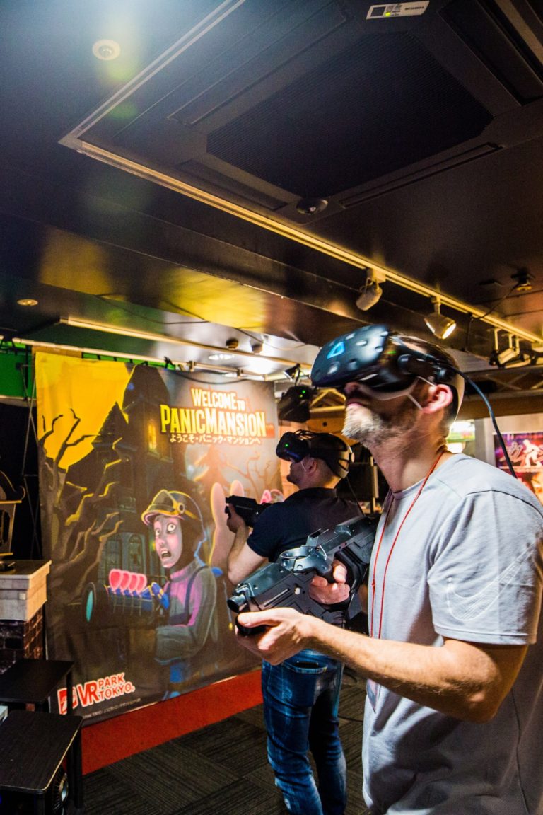 A man plays a digital game with VR glasses in Tokyo, Japan.