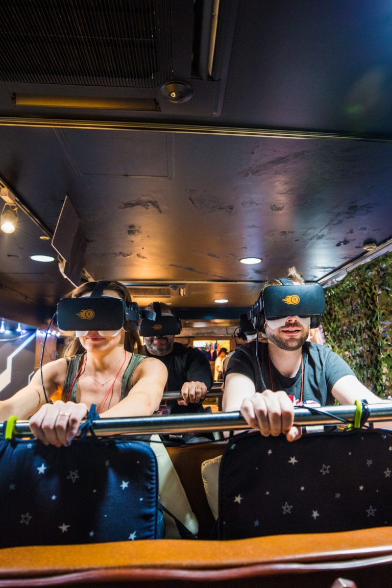 A man and a woman wearing VR glasses while sitting on a ride in Tokyo, Japan