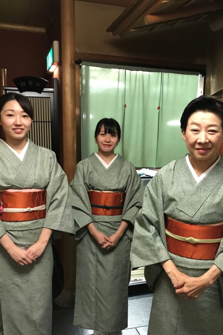 Three women smile into the camera with their kimonos in Tokyo, Japan.