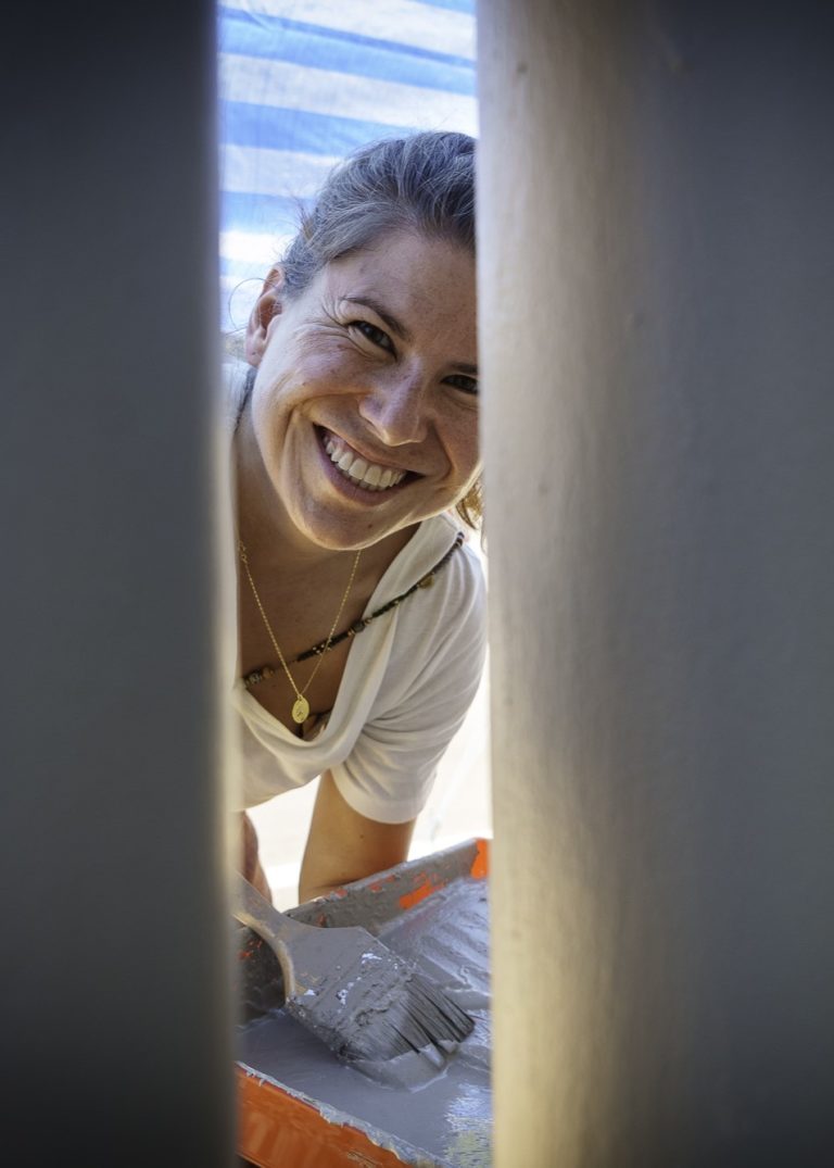 Nina from the events team smiles while painting during a CSR project in Phuket Thailand.