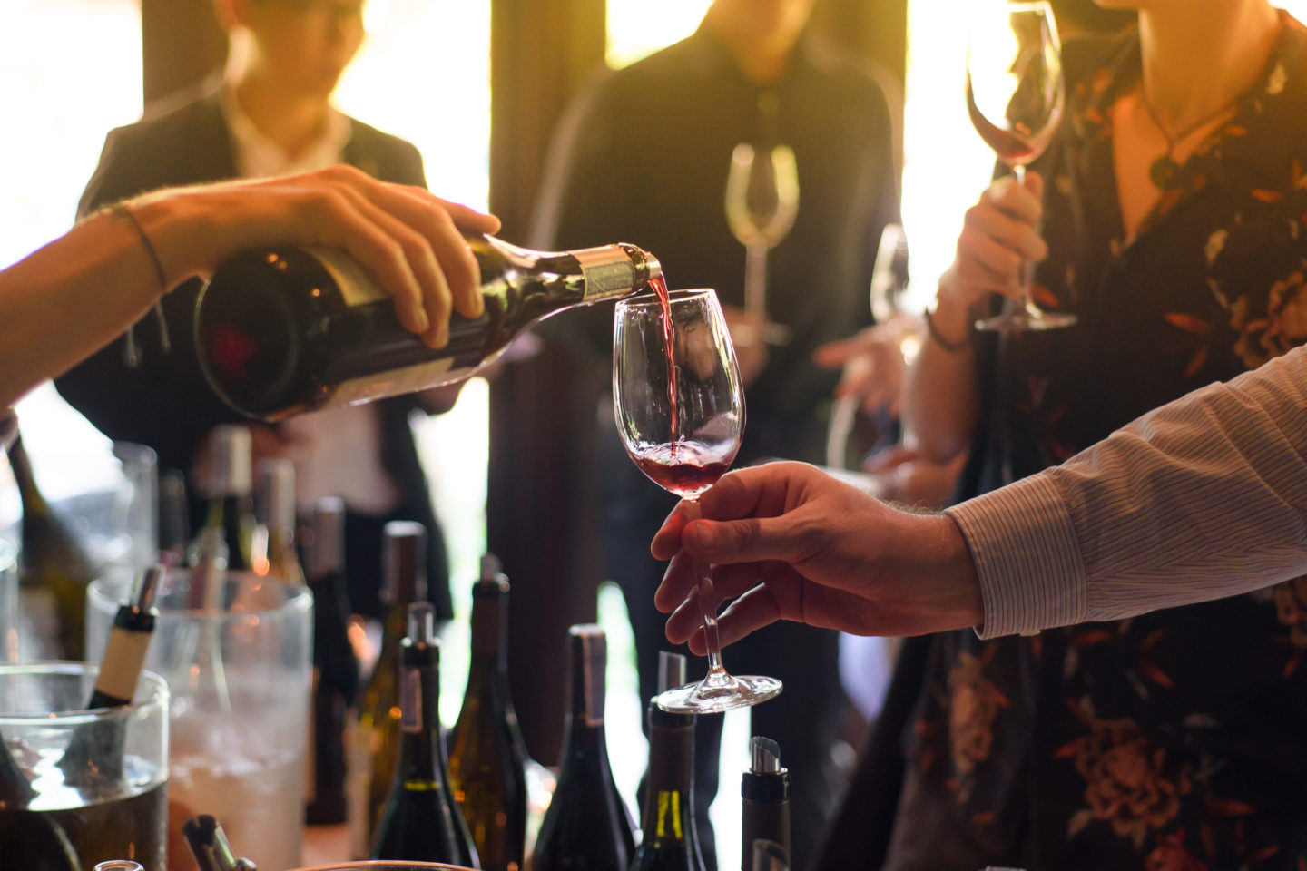 A waitress pours a glass of wine for a guest during a wine tasting.