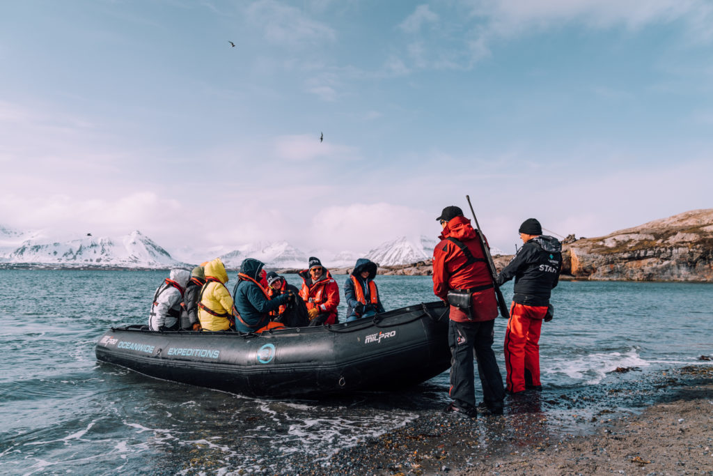 A group of people sit in a boat for an excursion in the Arctic Ocean off Spitsbergen.