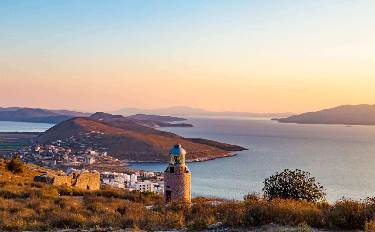 A scenic lighthouse gazes over the sea, highlighting Albania's charming Ottoman-era towns and beautiful coastline.