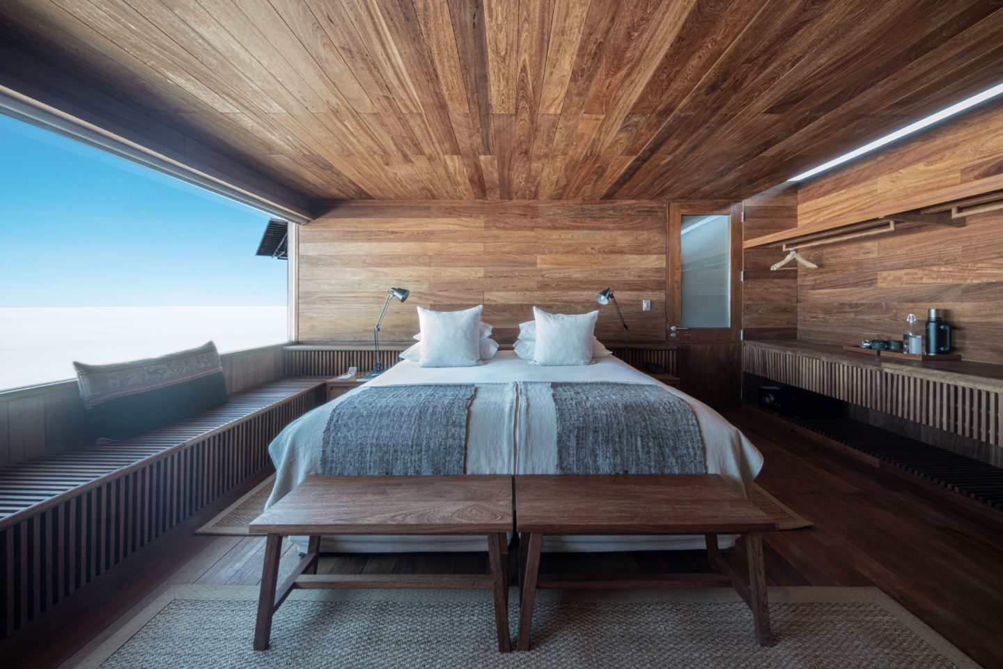 A well-appointed bedroom with wooden accents and large windows