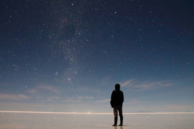 Vast expanse of salt flats stretching to the horizon under a dramatic sky