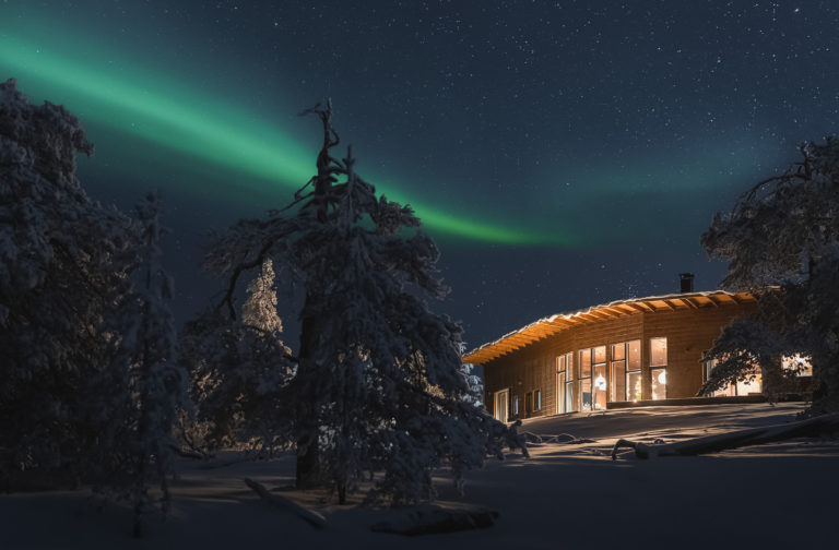 Breathtaking view of the Aurora Borealis dancing above a cozy cabin