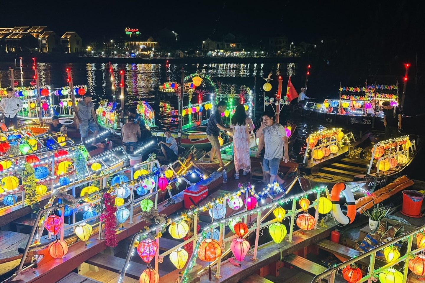 Colorful lights dance across boats in Hoi An, creating a magical evening ambiance